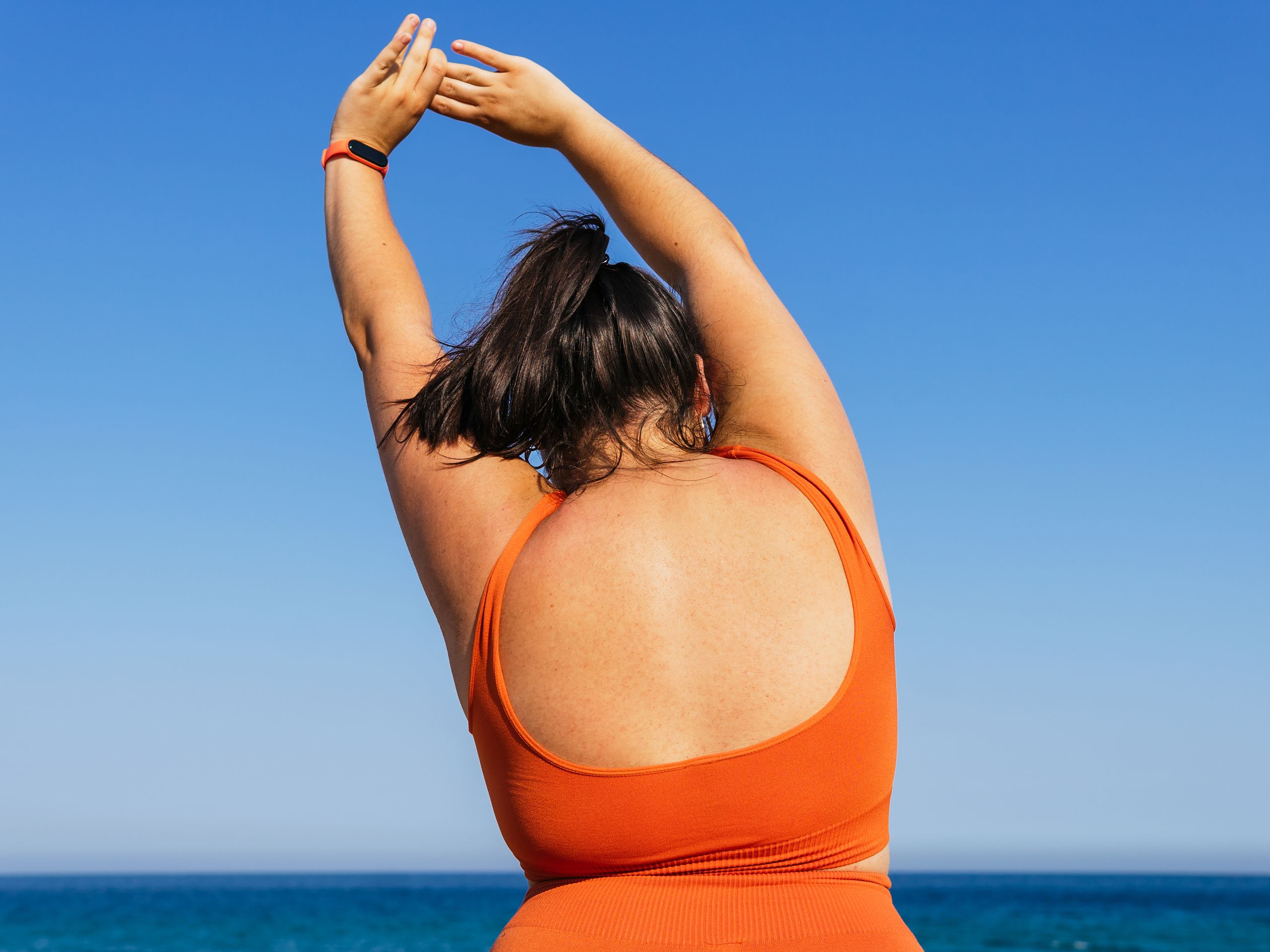 Back view of a woman in athleisure wear stretching