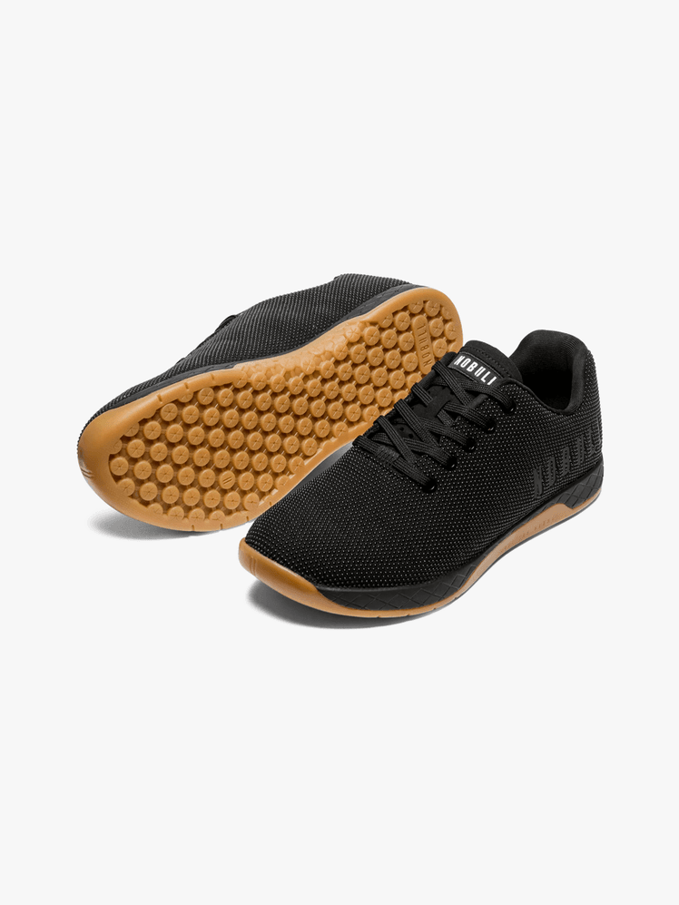 Outwork sneakers in branded black and brown color way on light gray background